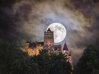 bran castle at night under full moon