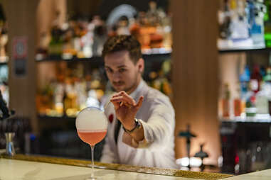 bartender mixes a fancy cocktail at a bar