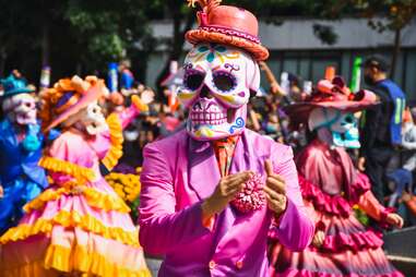 man wearing skull mask at day of the dead parade