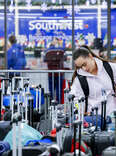 A woman searches for a suitcase in a baggage holding area for Southwest Airlines at Denver International Airport on December 28, 2022 in Denver, Colorado.