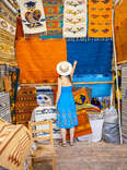 a woman looking at colorful rugs in Mexico 