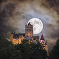 bran castle at night under full moon