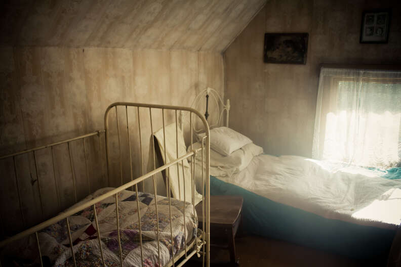 a bed and a crib in an attic space